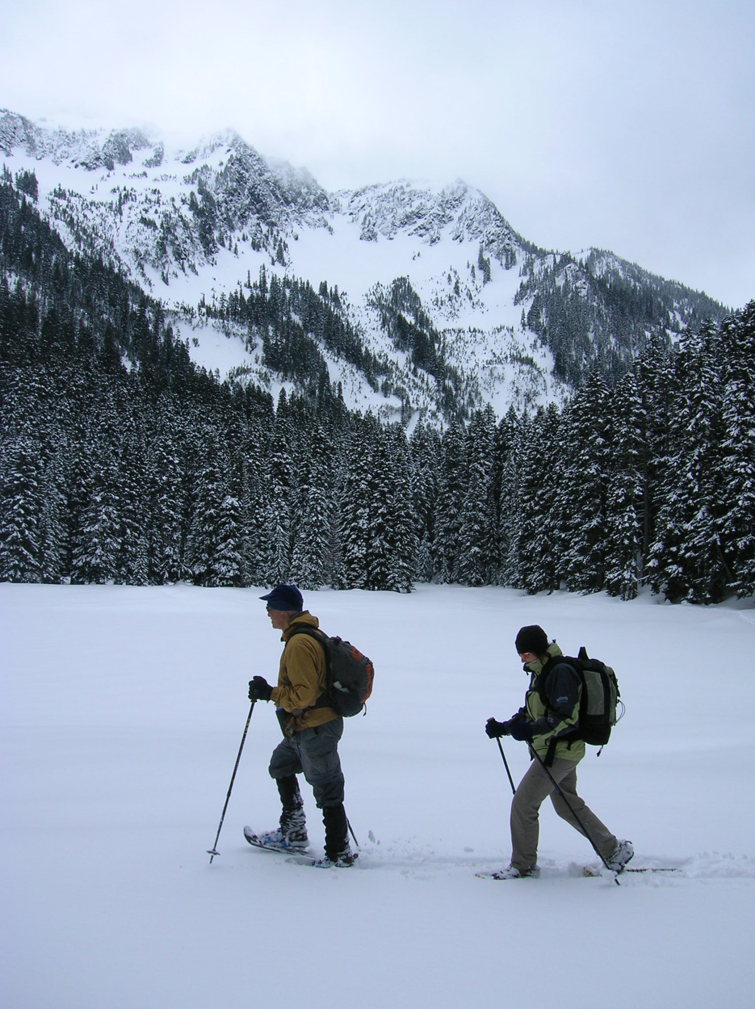 A pair of snowshoers make tracks across a frozen Lanham Lake